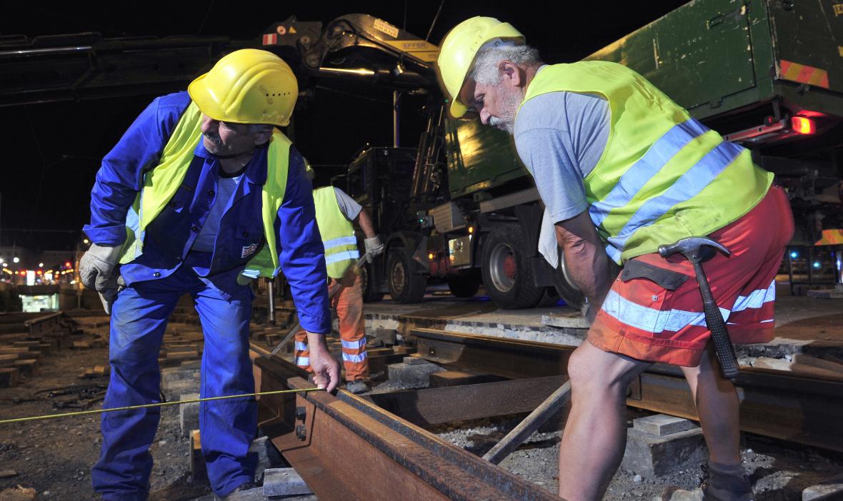 Gleisbauarbeiter bauen bei Nacht neue Schienen ein
