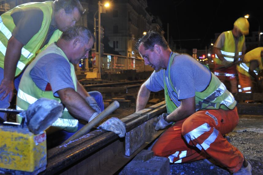 track construction workers lay new tracks at night