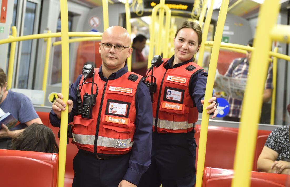 zwei Sicherheitsdienstmitarbeiter in Wiener Linien Dienstkleidung mit roten Westen in einer Ubahn